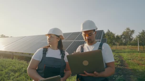 Man Woman Hard Hats Laptop Discussing Work Tasks Backdrop Solar — Stock Video