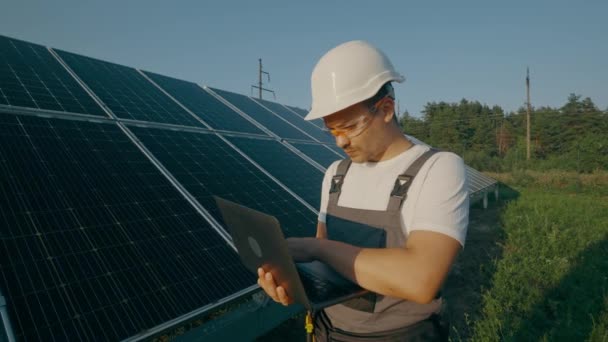 工程师在太阳能电池板站附近与笔记本电脑一起工作 太阳能电池板的检查和分析 可再生能源工人 现代电力 高质量的4K镜头 — 图库视频影像