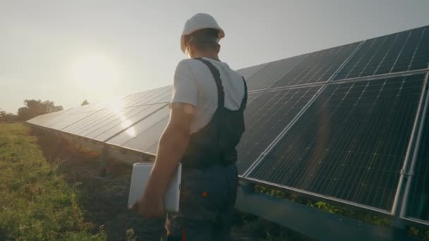 一名持有证件的男工在太阳能电池板站执行工作任务 监测发电系统的运作情况 绿色电力概念 高质量的4K镜头 — 图库视频影像