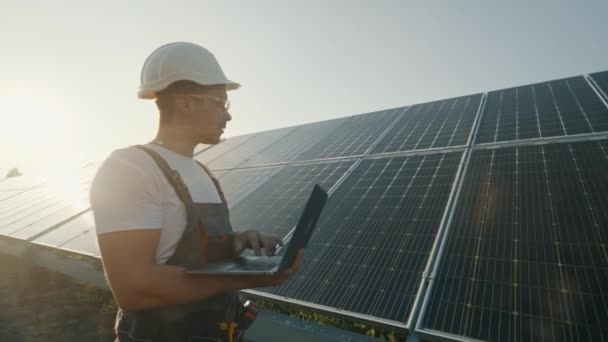 工程师在太阳能电池板站附近与笔记本电脑一起工作 太阳能电池板的检查和分析 可再生能源工人 现代电力 高质量的4K镜头 — 图库视频影像