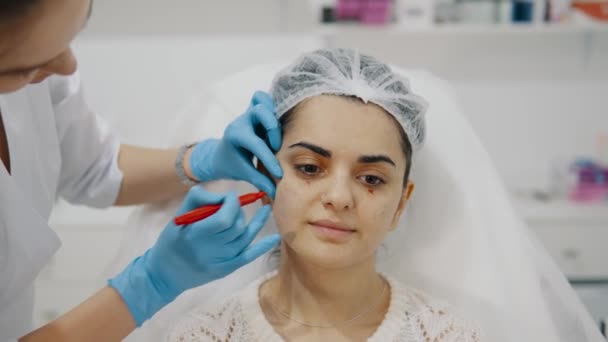 化粧品師は注射のために顔面に印を付けます 美容院でプロのスキンケア 痛みのない若返りの手順 しわを滑らかにして下さい 良質4K映像 — ストック動画