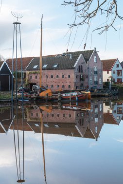Hollanda 'da eski bir ev ve tekne. Dokkum 'daki eski bir ev ve tekneden yüksek kaliteli fotoğraf..