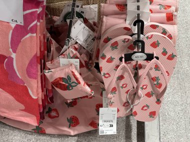 Varşova, Polonya - 28 Nisan 2025: Çilek tasarımlı pembe terlikler ve plaj havluları yaz moda aksesuarları mağazasında sergileniyor