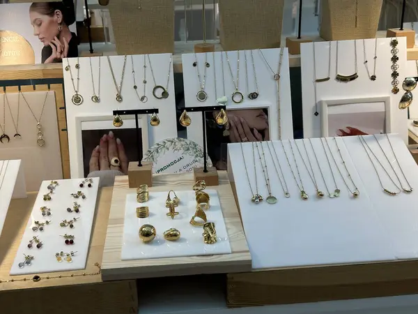 Varşova, Polonya - 28 Nisan 2025: Modern bir perakende satış ortamında kolyeler, yüzükler ve küpelerle sergilenen şık altın mücevher koleksiyonu