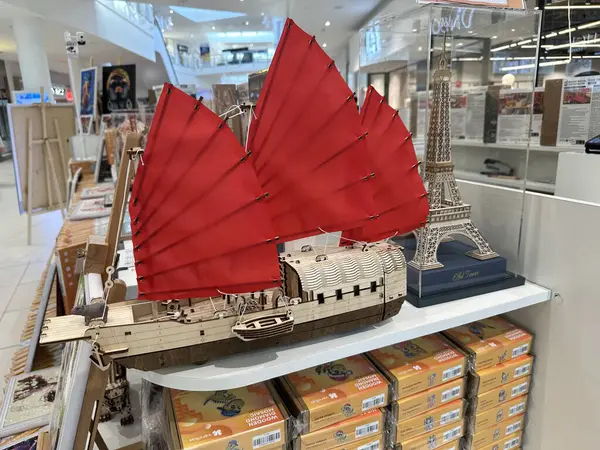 Varşova, Polonya - 28 Nisan 2025: Bir hediyelik eşya dükkanında Eyfel Kulesi 'nin yanında kırmızı yelkenli bir Çin hurda gemisinin modeli