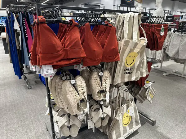 Varşova, Polonya - 28 Nisan 2025: Perakende mağazasında rafta kırmızı mayo ve bej sandaletlerin sergilenmesi