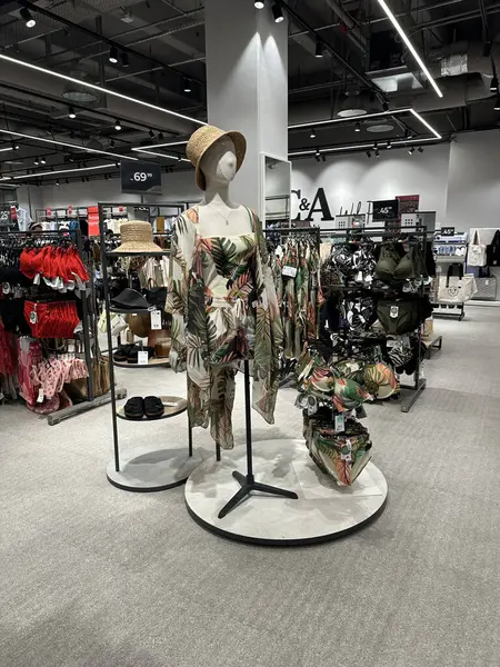 Varşova, Polonya - 28 Nisan 2025: Çağdaş perakende mağaza ortamında şık aksesuarlarla birlikte tropikal baskı giysileri sergilendi