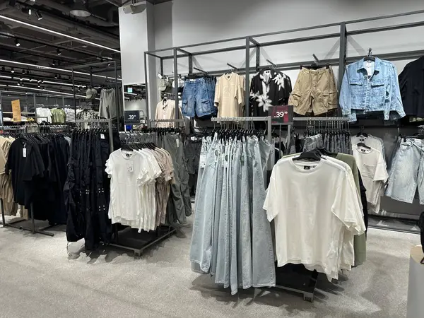 Varşova, Polonya - 28 Nisan 2025: Perakende giyim sergisi, raflarda net fiyat etiketleri ve modern ortam ile çeşitli stil ve renkler sergiliyor