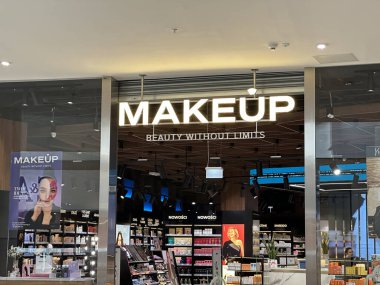 Varşova, Polonya - 28 Nisan 2025: Parlak bir tabela ve raflarda bir dizi güzellik ürününün ve tanıtım afişlerinin yer aldığı bir MAKEUP mağazasının girişi müşteriler için davetkar bir ortam yarattı
