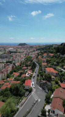 Nice, Fransa 'nın hava manzarası, kentsel binalar, terracotta çatıları ve virajlı yollar. Akdeniz açık mavi bir gökyüzünün altında arka planda görünür..