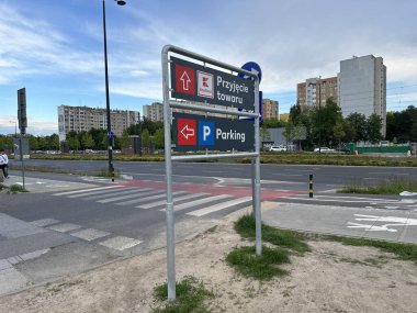 Varşova, Polonya - 22 Mayıs 2025: Kentsel tabela, hareketli bir şehir manzarasında yön bulma ve park yönlerini gösteriyor
