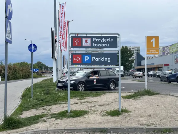Varşova, Polonya - 22 Mayıs 2025: Polonya 'da trafik işaretli park alanı, yeşil ve ticari binalarla çevrili rehberlik araçları