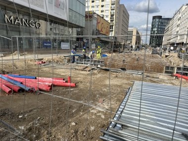 Varşova, Polonya - 22 Mayıs 2025 Etrafı renkli şeker paketleri ve oyuncaklarla çevrili küçük yuvarlak kurabiyelerle çevrili bir elin yakın çekimi, keyifli ve davetkar bir sahne yaratıyor