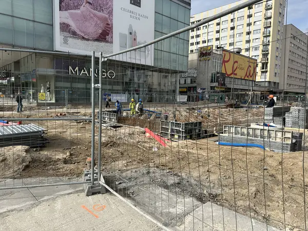 Varşova, Polonya - 22 Mayıs 2025 Etrafı renkli şeker paketleri ve oyuncaklarla çevrili küçük yuvarlak kurabiyelerle çevrili bir elin yakın çekimi, keyifli ve davetkar bir sahne yaratıyor