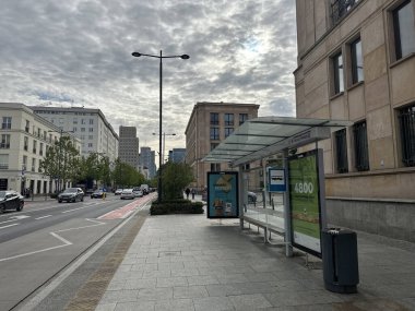 Varşova, Polonya - 22 Mayıs 2025: Şehir otobüs durağı modern binalar, bulutlu gökyüzü ve araçlarla şehir hayatının ve toplu taşımacılığın özünü yakalıyor
