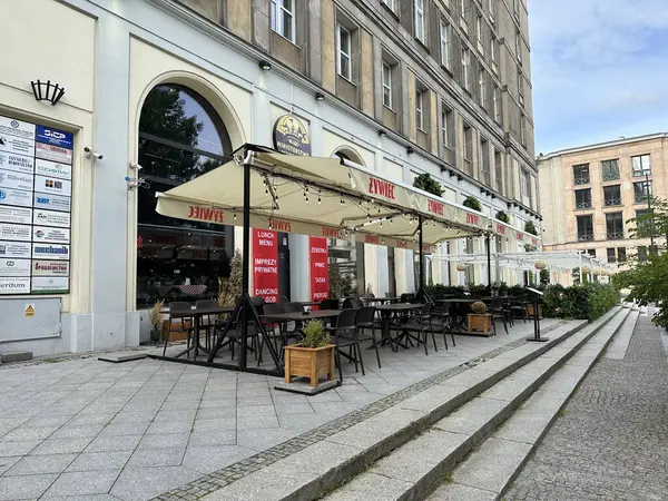Varşova, Polonya - 22 Mayıs 2025: Bir restoranın açık hava oturma alanı şık mobilya ve şemsiyeler içeriyor ve kentsel yemek deneyimi yaratıyor