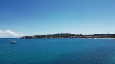 Fransa 'nın Antibes şehrinde bulunan Grimaldi Şatosu ve Muse Picasso' nun yer aldığı Cote d 'Azur manzarası. Sahne berrak mavi bir gökyüzü ve sakin turkuaz suları içeriyor..