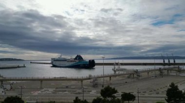 Marsilya 'nın Eski Limanı' ndan geçen büyük bir yolcu gemisinin insansız hava aracı videosu. Tarihi rıhtım binaları, rıhtımlı tekneler, Saint-Jean Kalesi. Seyahat videoları, turizm promosyonları, seyahat endüstrisi.