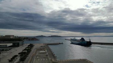 Fransa, Marsilya Limanı 'na giren bir kargo gemisinin hava görüntüleri. Endüstriyel liman bölgesi, konteynırlar, vinçler, çevreleyen deniz. Ticari liman operasyonları ve küresel ticaret kavramı