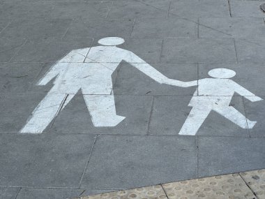 Varşova, Polonya - 22 Mayıs 2025: Yaya geçidi grafikleri yetişkin ve çocuğun kaldırımda el ele tutuşup şehir ortamında güvenliği ve aileyi ön plana çıkardığını gösteriyor