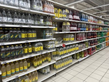 Varşova, Polonya - 22 Mayıs 2025: Canlı bir alışveriş atmosferinde çeşitli marka ve tatların yer aldığı süpermarket raflarında çeşitli meşrubat çeşitleri