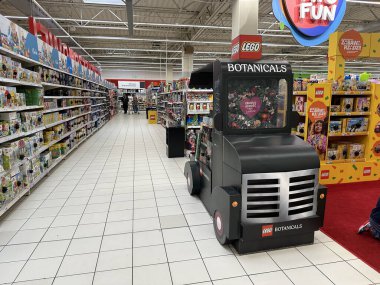 Varşova, Polonya - 22 Mayıs 2025: LEGO Botanik kamyonları renkli ürünler ve alışveriş yapan müşterilerle dolu canlı bir oyuncak mağazası koridorunda duruyor