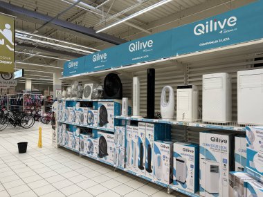 Varşova, Polonya - 22 Mayıs 2025: Qilive marka cihazlar canlı bir alışveriş atmosferinde perakende satış mağazasında perakendeciler ve klimaların yer aldığı raflarda düzgün bir şekilde düzenlenmiştir.