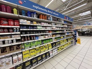 Varşova, Polonya - 22 Mayıs 2025: Markette çeşitli beslenme malzemeleri ve beslenme ürünleriyle dolu raflar, canlı ambalaj ve organizasyonu vurguluyor