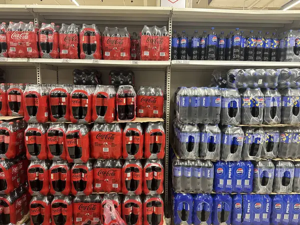 Varşova, Polonya - 22 Mayıs 2025: Coca-Cola ve Pepsi şişeleri süpermarket raflarında belirgin bir şekilde sergilenerek, tüketiciler için popüler meşrubat seçeneklerini vurguluyor