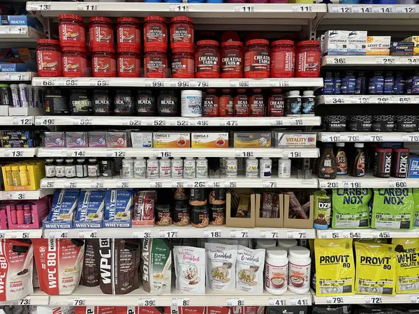 Varşova, Polonya - 22 Mayıs 2025: Raflarda renkli ambalajlar ve organize düzenlemeler içeren çok çeşitli protein takviyeleri ve sağlık ürünleri sergilenmektedir