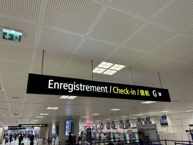 Nice, Fransa - 10 Mayıs 2025: Havalimanı check-in tabelası Fransızca, İngilizce ve Çince bilgi içeriyor, yolculara uçuş için kayıt alanına kadar rehberlik ediyor