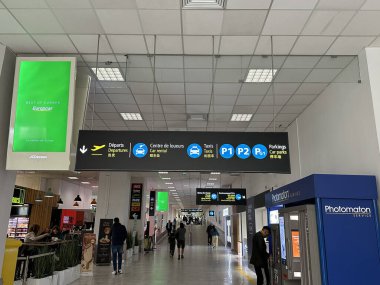 Nice, Fransa - 10 Mayıs 2025: Havalimanı terminalinin içi hareketli çevrede yön işaretleri, dükkanlar ve gezginler barındırıyor