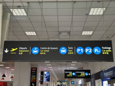 Nice, Fransa - 10 Mayıs 2025: Havaalanı tabelası kalkış, araba kiralama, taksiler ve park alanları için yol tarifi gösteriyor.