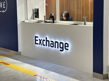 Nice, Fransa - 10 Mayıs 2025: Döviz kurunda güncel finansal hizmet tasarımı vurgulanan aydınlatma işareti ve odaklanmış personel