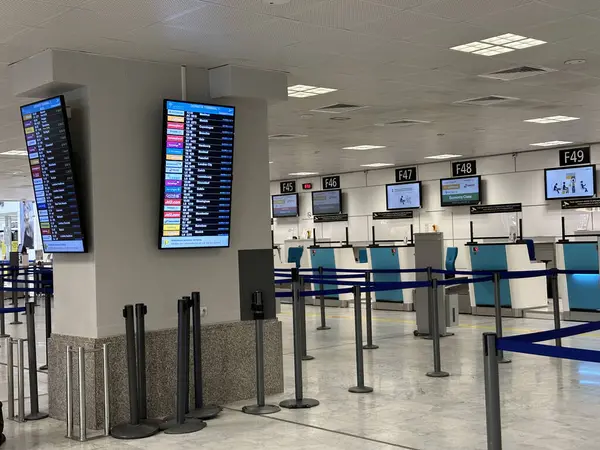 Nice, Fransa - 10 Mayıs 2025: Havalimanı check-in bölgesi, uçuş bilgilerini gösteren dijital görüntüler, boş sayaçlar ve gezginler için geniş bir yerleşim alanı