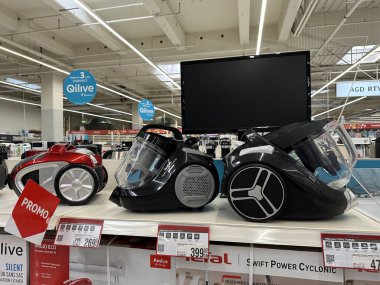 Varşova, Polonya - 22 Mayıs 2025: Üç şık elektrik süpürgesi tanıtım tabelalı ve parlak bir mağaza atmosferli bir perakende mağazasında sergileniyor