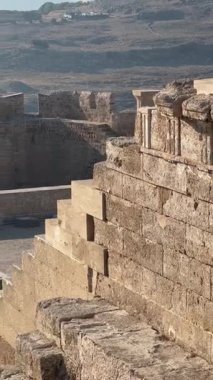 Yıpranmış taş kalede güçlü duvarlar ve siperler yer alıyor, tarihi mimari ve arkeolojik öneme dikkat çekerek sakin bir açık hava ortamında