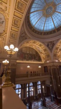 Prag, Çek Cumhuriyeti - 22 Nisan 2023: Güzelce tasarlanmış, duvar resimleri ve avizelerle süslenmiş görkemli bir iç uzay, zarafet ve tarihsel öneme sahip bir atmosfer yaratıyor.