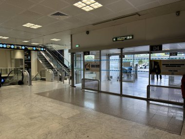 Nice, Fransa - 10 Mayıs 2025: Yürüyen merdivenleri ve cam kapıları olan, seyahat atmosferi ve geniş tasarımı vurgulayan çağdaş havaalanı terminali