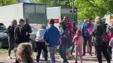 Varşova, Polonya - 16 Mayıs 2025: Holi festivalini dışarıda kutlayan çeşitli bireyler, neşeyle renkli tozlarla kaplanmış, canlı bir sahne yaratıyorlar.