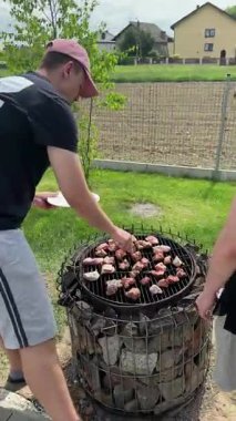 Varşova, Polonya - 16 Mayıs 2025: Barbeküde ızgara yapılan çeşitli etler, canlı bir açık hava ortamında kömür üzerindeki farklı kesikleri vurguluyor