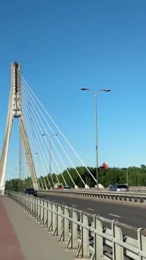 Varşova, Polonya - 16 Mayıs 2025: Kablo destekli köprü, modern mimari ve kentsel gelişimi ön plana çıkaran zarif çizgiler ve açık mavi bir gökyüzü içeriyor