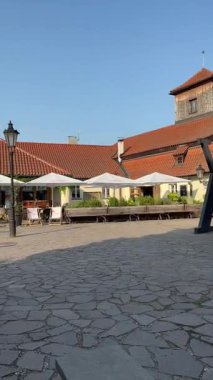 Prag, Çek Cumhuriyeti - 23 Nisan 2023: Kafe ve yeşilliklerle çevrili, parke taşlı bir meydanda iki heykelin bronz heykeli