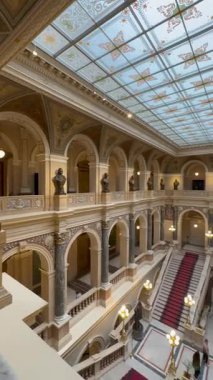 Prag, Çek Cumhuriyeti - 23 Nisan 2023: Tarihi yapının büyük merdivenlerinde zarif ışıklandırma ve karmaşık tavan tasarımı, ziyaretçileri mimari güzelliği keşfetmeye davet ediyor.