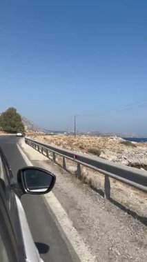 Rodos, Yunanistan - 17 Ağustos 2023: Berrak mavi gökyüzünün altında kayalık bir arazi, doğal güzelliği ve açık hava keşiflerini ön plana çıkarıyor