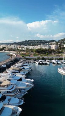 Gök mavisi kıyı manzarası, marinada yatlar ve Fransa 'nın Cannes kenti. Açık mavi gökyüzü ve arka planda yemyeşil tepeler. Seyahat acenteleri, havayolları, tur operatörleri, vloglar, instagram