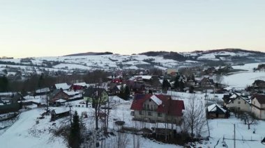 Karla kaplı pitoresk bir köy, tuhaf evler ve yuvarlanan tepelerle, baş döndürücü doğal güzellikte huzurlu bir kış ortamı yaratıyor.