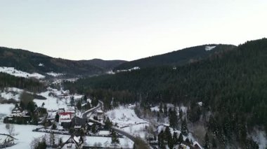 Manzaralı kış manzaraları, karla kaplı tepeler, virajlı yollar, büyüleyici evler ve yoğun ormanlar, huzurlu ve sakin bir ortam çağrıştırıyor.