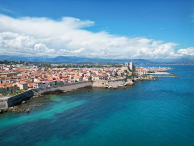 Renkli mimarisi, tarihi kulesi ve dingin turkuaz suları olan canlı bir sahil kasabasının havadan görünüşü çarpıcı bir sahil atmosferi yaratıyor.