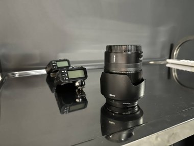 Varşova, Polonya - 01 Temmuz 2025: Nikon lensleri parlak yüzeyde, arkasında kamera tetikleyicileri ile profesyoneller için gerekli fotoğraf ekipmanlarını vurguluyor